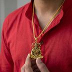 Lord Hanuman Golden Pendant With Chain with a pendant held by a person.